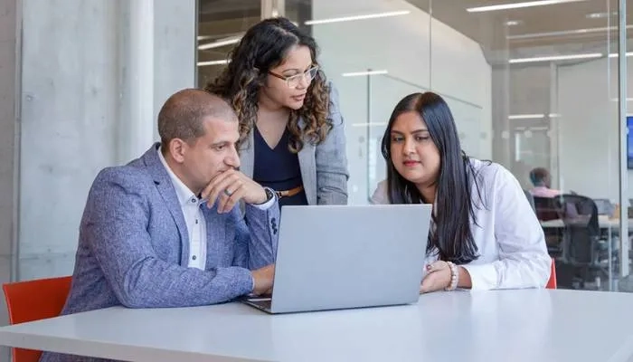 Group of colleagues looking at laptop